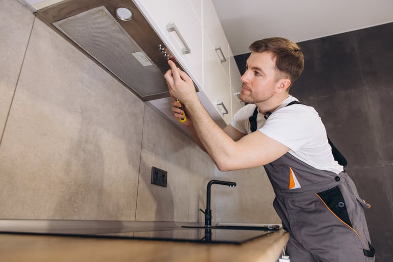 Plumber working in modern kitchen